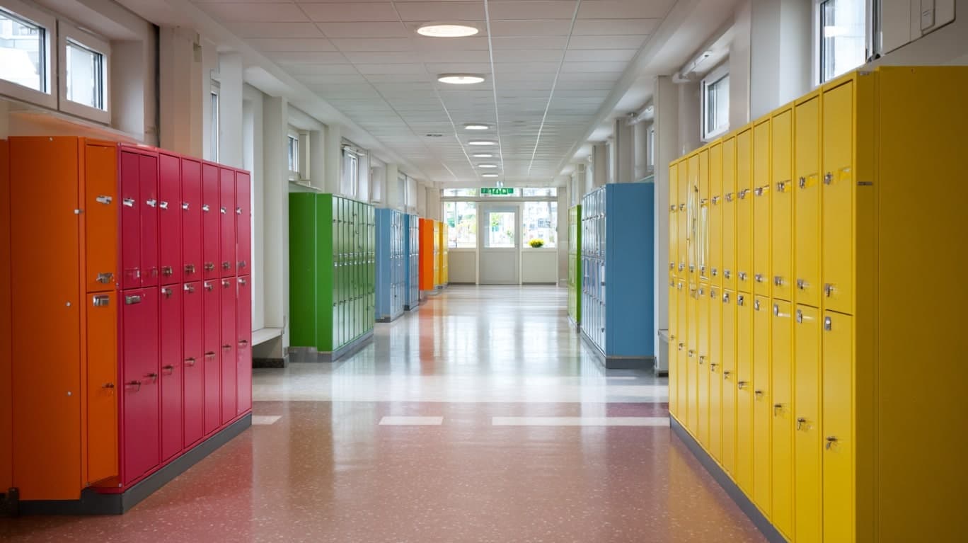 Żółte, czerwone, zielone i niebieskie szafki dla uczniów w szkole podstawowej